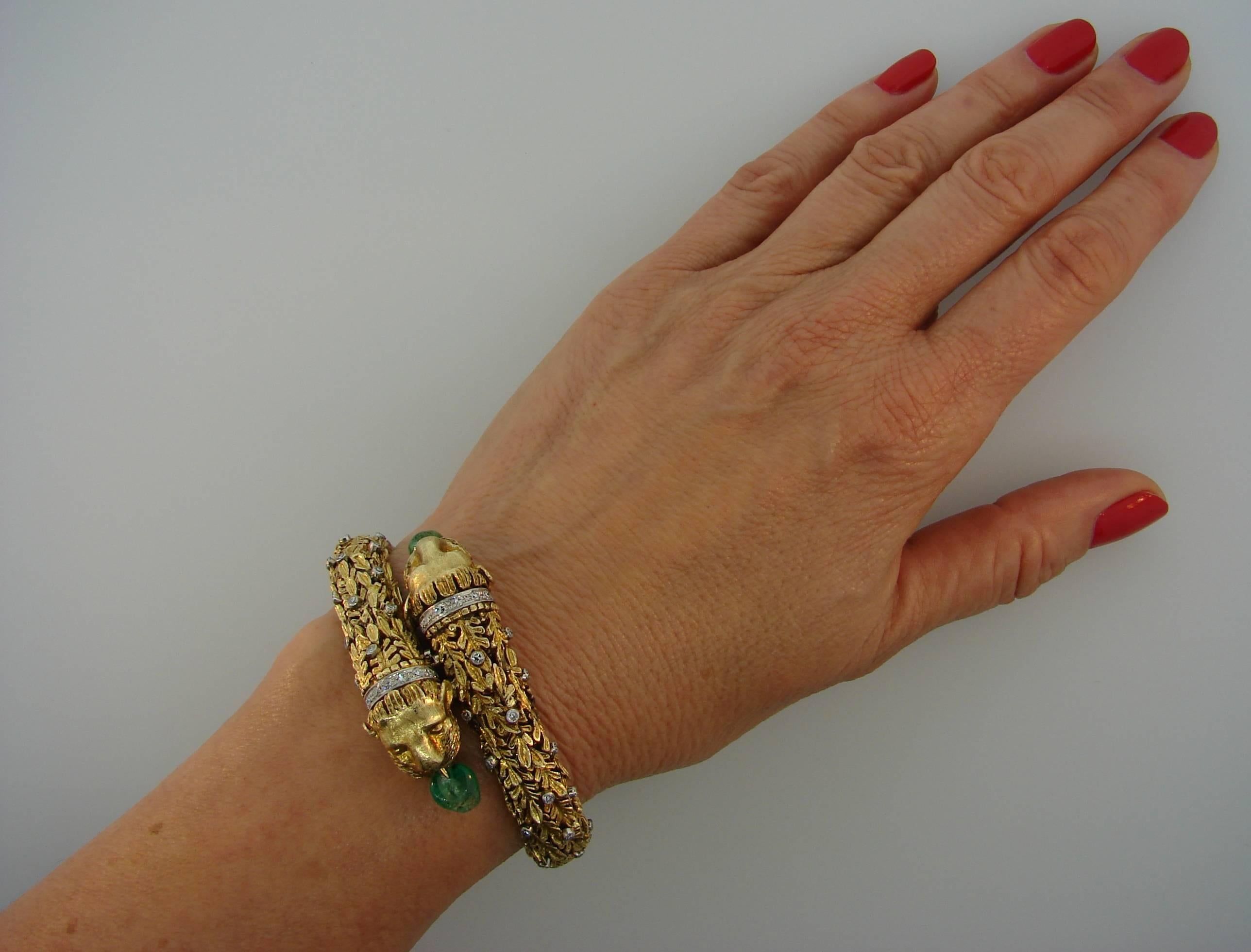 Recognizable Chimera Heads bangle bracelet created by Zolotas in the 1970's. Ornate and made with great attention to details, it is definitely a conversational piece. 
It is made of 18 karat yellow gold, set with single cut diamonds and two emerald
