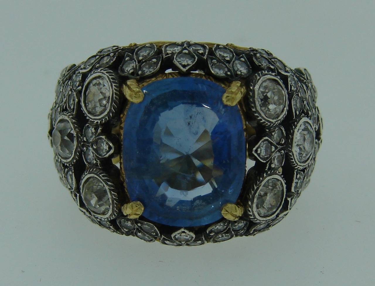 Gorgeous cocktail ring created by Buccellati in the 1960's. Features an approximately 7.34-ct cushion cut natural sapphire set in 18k white and yellow gold and accented with Old European cut and single cut diamonds (total weight is approximately