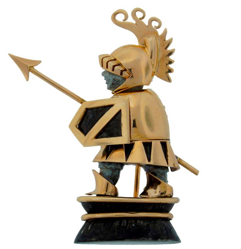 Fun and cute pin created in the 1960s. It is designed as a warrior or knight ready to protect his family and property and whatever else is in danger. It is made of a stone and 14k (tested) yellow gold. 
It is 2-1/8