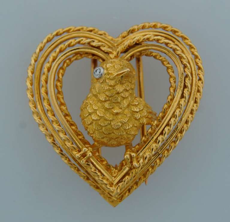 Romantic cute pin created by Cartier in Paris in the 1960s. Features a lovely bird in an open heart. made of 18k yellow gold; the bird's eye is accented by a diamond.
Measures 1-1/8