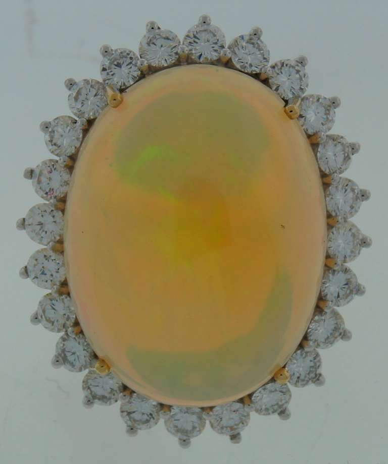 Stunning cocktail ring featuring an Australian opal framed with diamonds and set in platinum and gold.
Size 6.5 - 6.75; re-sizable.
The opal measures 28.0 x 21.32 x 10.85 mm and weighs approximately 37 carats. The opal is surrounded with 24 round