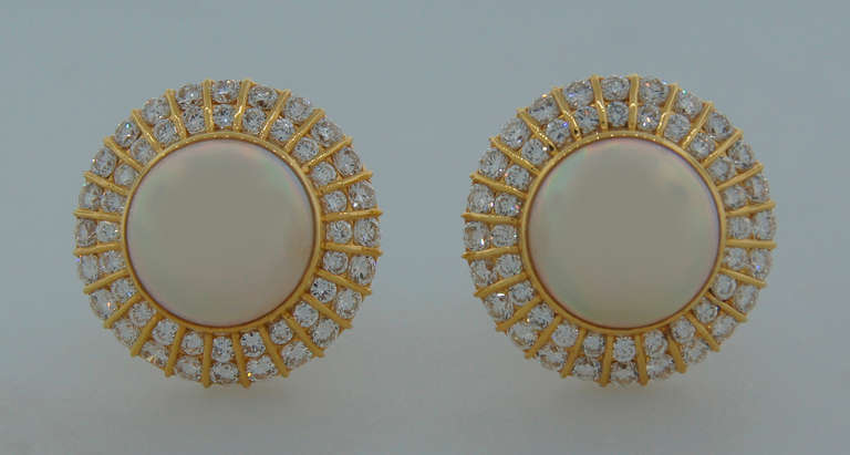 Magnificent and timeless earrings created by Tiffany & Co. in the 1970's. Feature two gorgeous mobe pearls set in yellow gold and framed in two rows of diamonds. The mobe pearls are 13.67 mm and 13.78 mm in diameter. 96 round brilliant cut diamonds