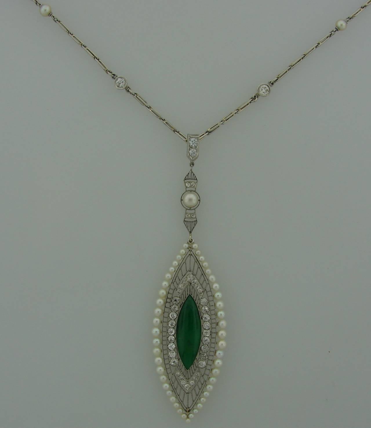 Gorgeous Belle Époque pendant created by Kreisler & Co. in New York. Features a marquise shape jade set in platinum and surrounded with old mine and Old European cut diamonds and graduating pearls. The pendant is attached to a platinum chain set