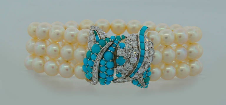 Feminine elegant bracelet created in France in the 1950's. Features three strands of Akoya pearls finished with a platinum clasp set with diamonds and turquoise. The clasp tongue is made of 18k white gold. The pearls have beautiful luster and are in