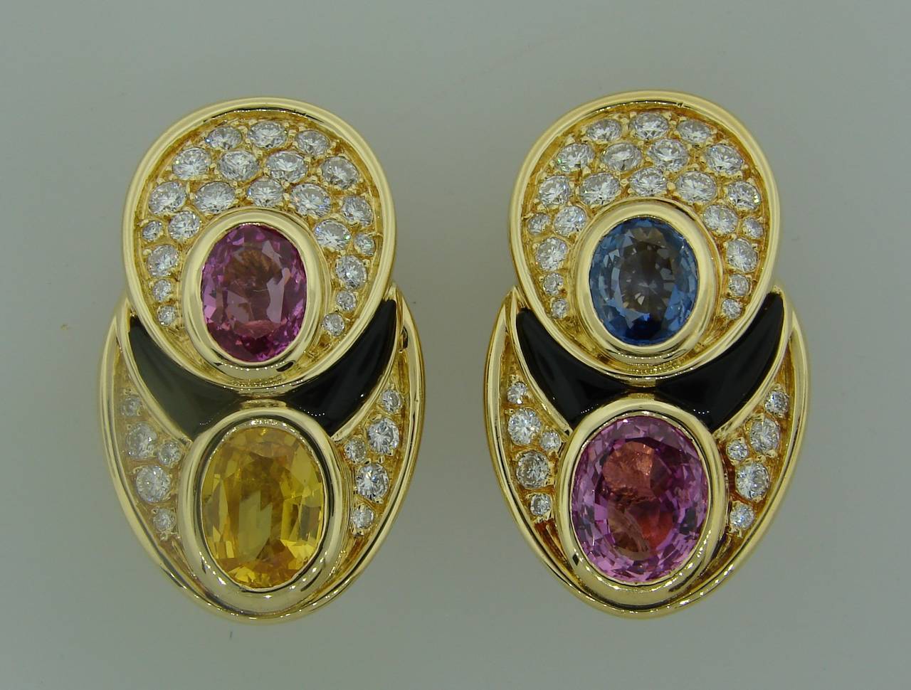 Colorful and bold clip-on earrings created by Marina B in France in the 1980's. Geometrical design, sharp lines, perfect proportions, tasteful color combination.
Made of 18k (stamped) yellow gold, features blue, pink and yellow sapphire, accented