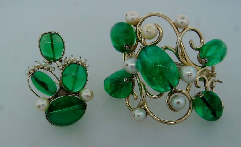Bold yet exquisite set consisting of a bracelet and a clip/pin created by Seaman Schepps in the 1950's. Features large emerald cabochons accented with white pearls. Set in 14k (tested) white gold. 
The bracelet is 2-5/8