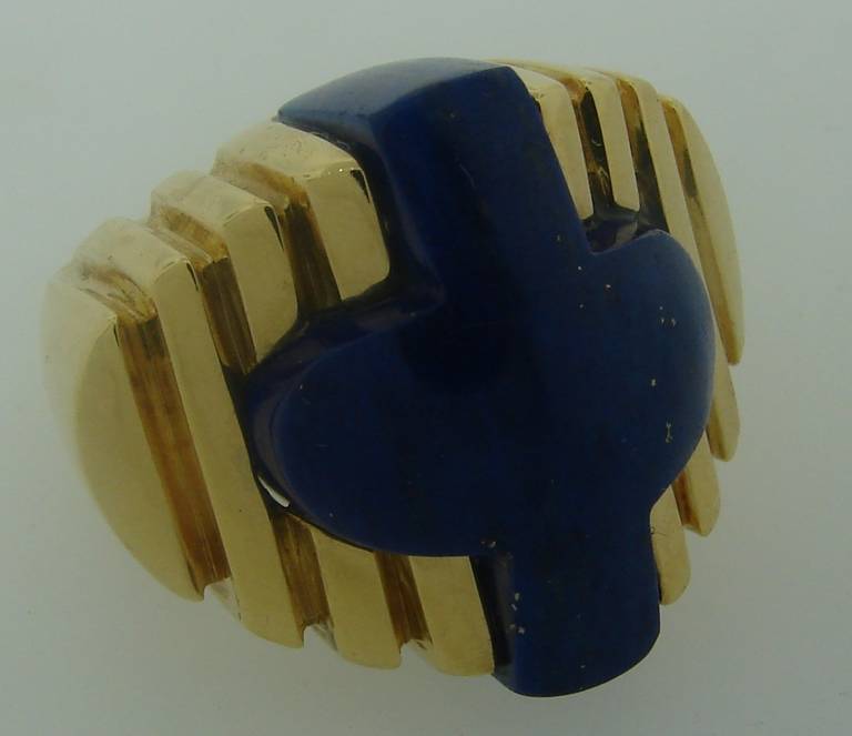 Bold and colorful ring created by Aldo Cipullo for Cartier in 1971. 
Features a  lapis lazuli stylized cross set in 18k yellow gold.
Prominent yet elegant, chic and wearable!
Size 6. The ring is 7/8