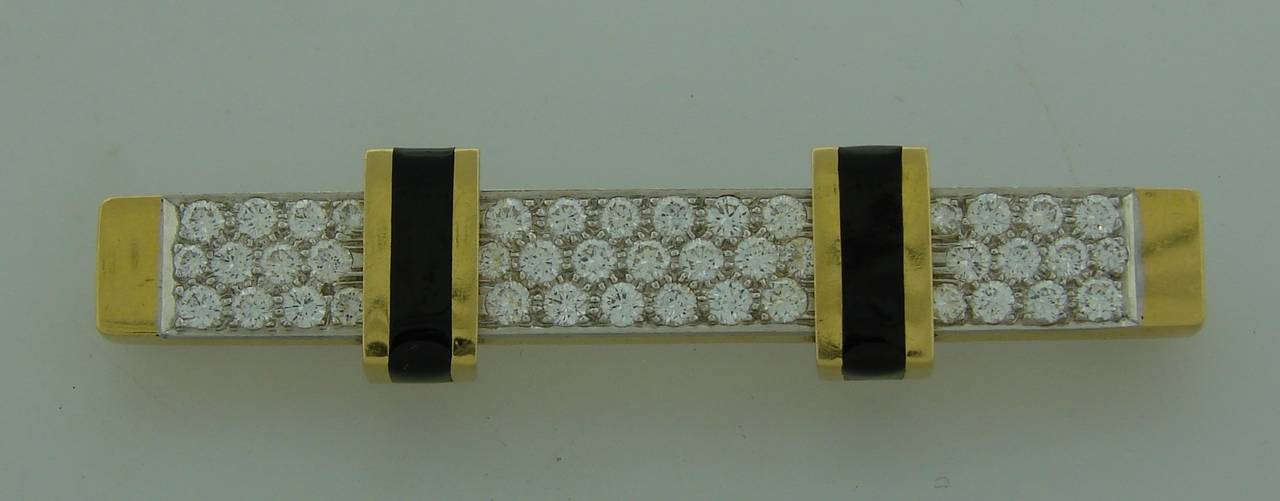Chic, bold yet elegant pin created  by David Webb in the 1980's. Made of 18k yellow gold, set with round brilliant cut diamonds and accented with black enamel. The diamonds are set in platinum which accentuates whiteness of the diamonds.
The pin is