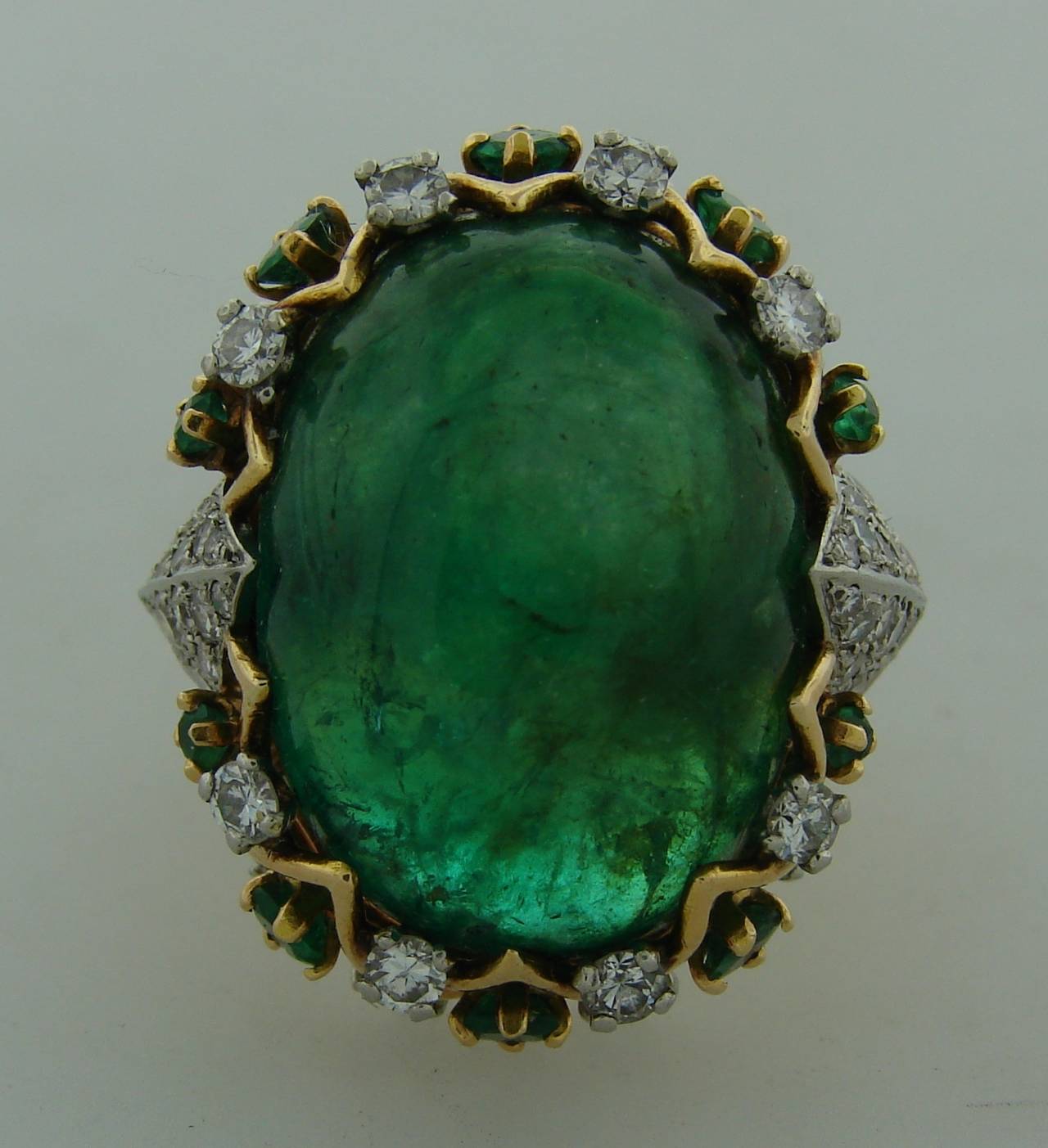 Exquisite cocktail ring created by Pierre Sterle in Paris in 1950's. French chic and elegant ring. Stylish and wearable, it is a great addition to your jewelry collection. 
Features an approximately 26-carat oval cabochon emerald set in 18k yellow