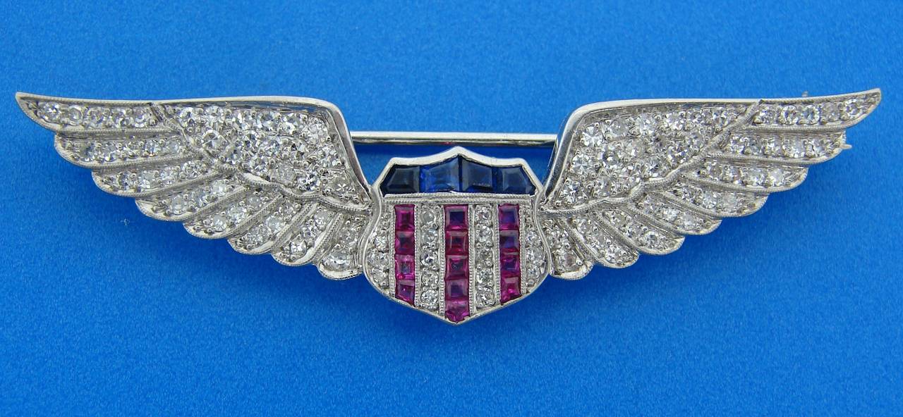 Fabulous and chic Army Aviator Wings Badge created by Cartier in the 1910's. It is made of palladium and set with single cut diamonds, table cut sapphires and rubies. It measures 2