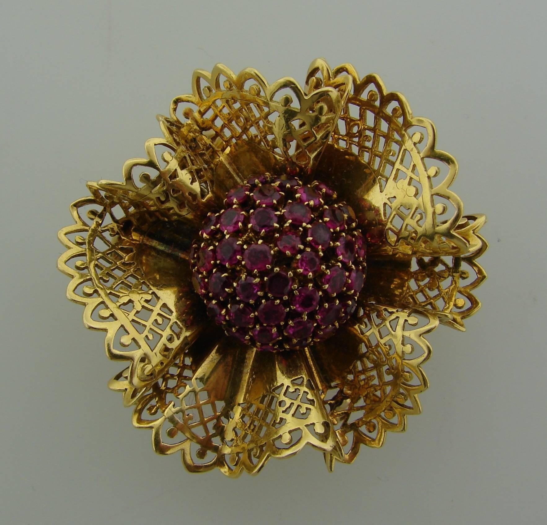 Adorable stylized flower pin created by Van Cleef & Arpels in France in the 1950's. Made of 18k yellow gold and set with forty five round faceted rubies (total weight approximately 3.50 carats).
The brooch will make a stylish accent to any outfit.