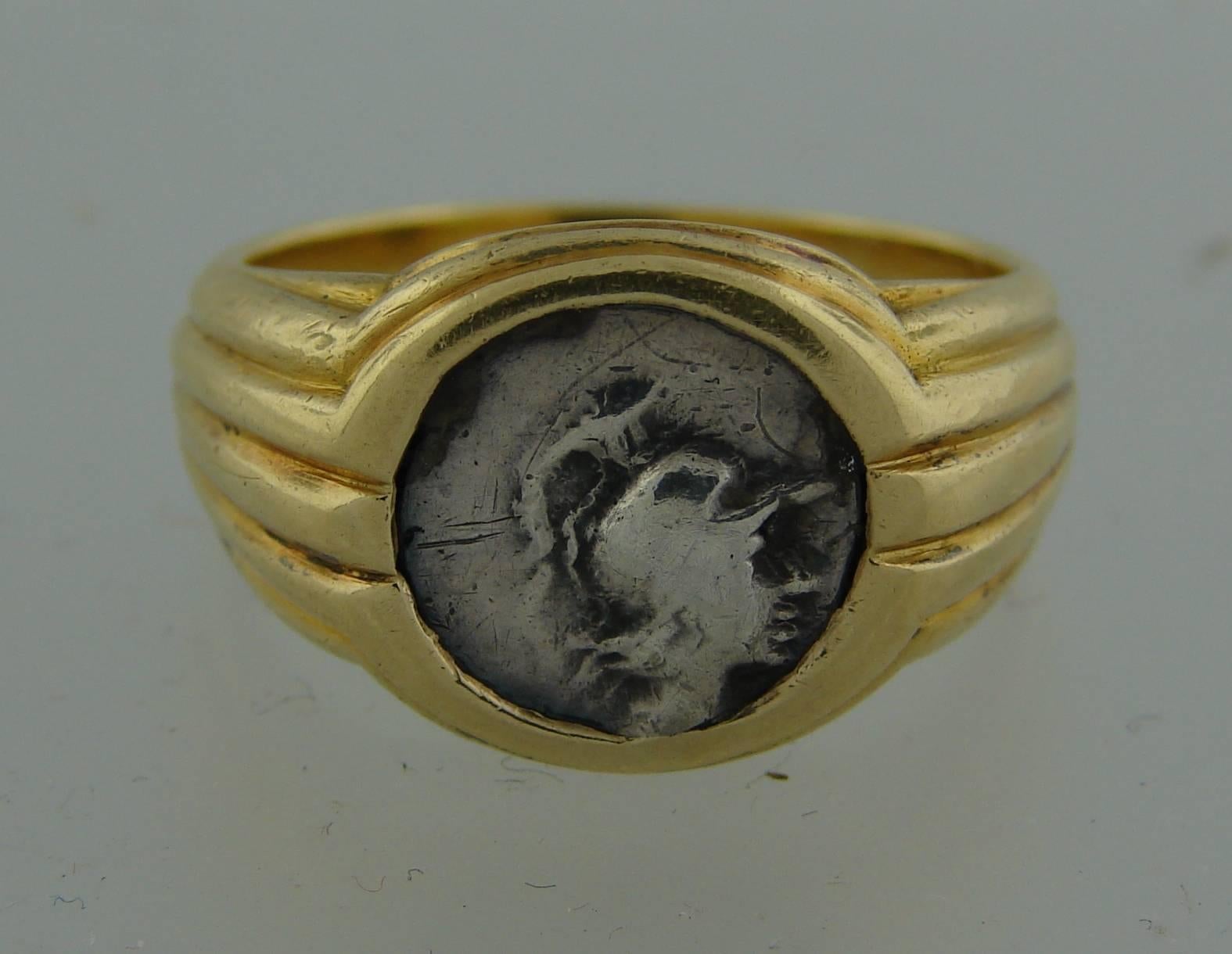 Signature Bulgari Münzring mit einer antiken Silbermünze, gefasst in 18 Karat Gelbgold. Die Münze ist CARIA HALIKARNAS 2. CENTURY B.C. 
Die Münze misst 3/8