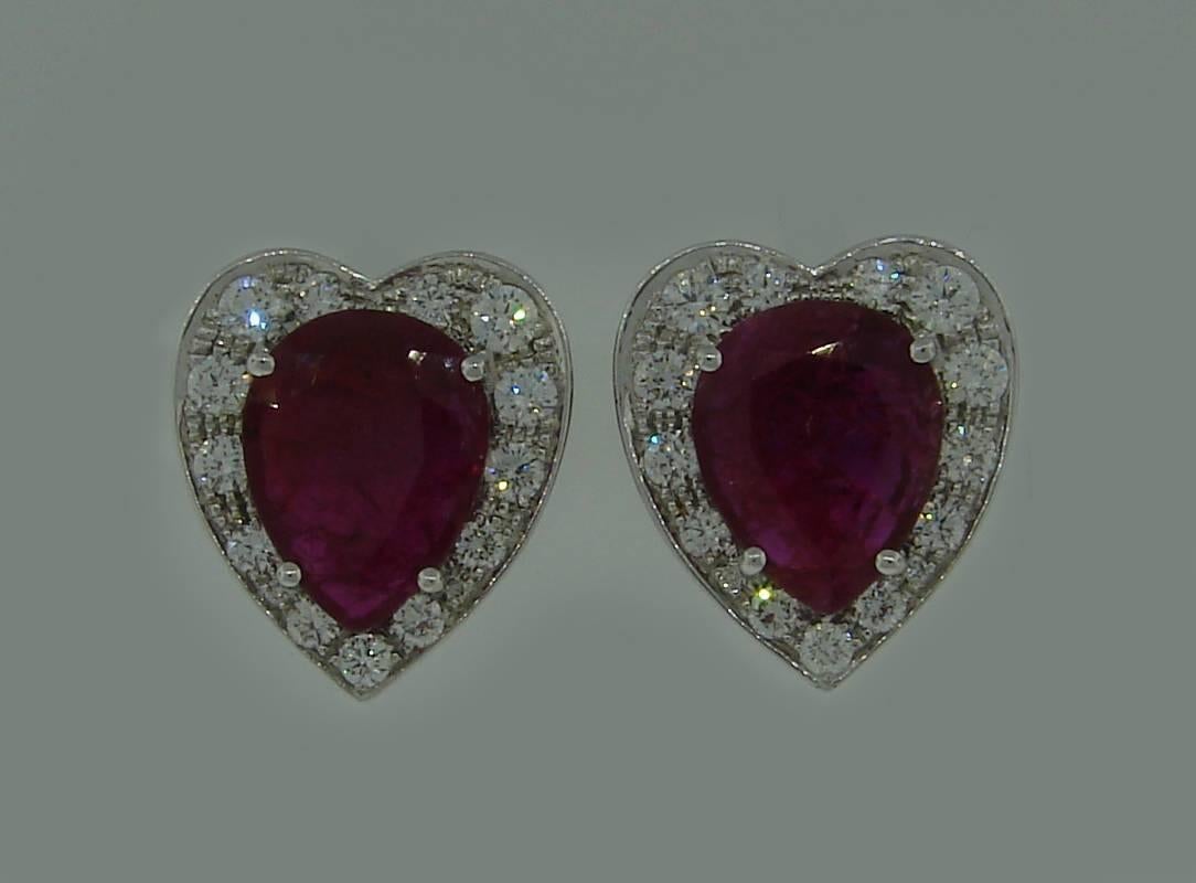 A pair of lovely heart-shape earrings featuring a pear-shape natural non-heated ruby framed with round diamonds set in 14k (tested) white gold. Rubies were examined in a Swiss Gem Lab and have a Gemstone Report stating that their total weight is