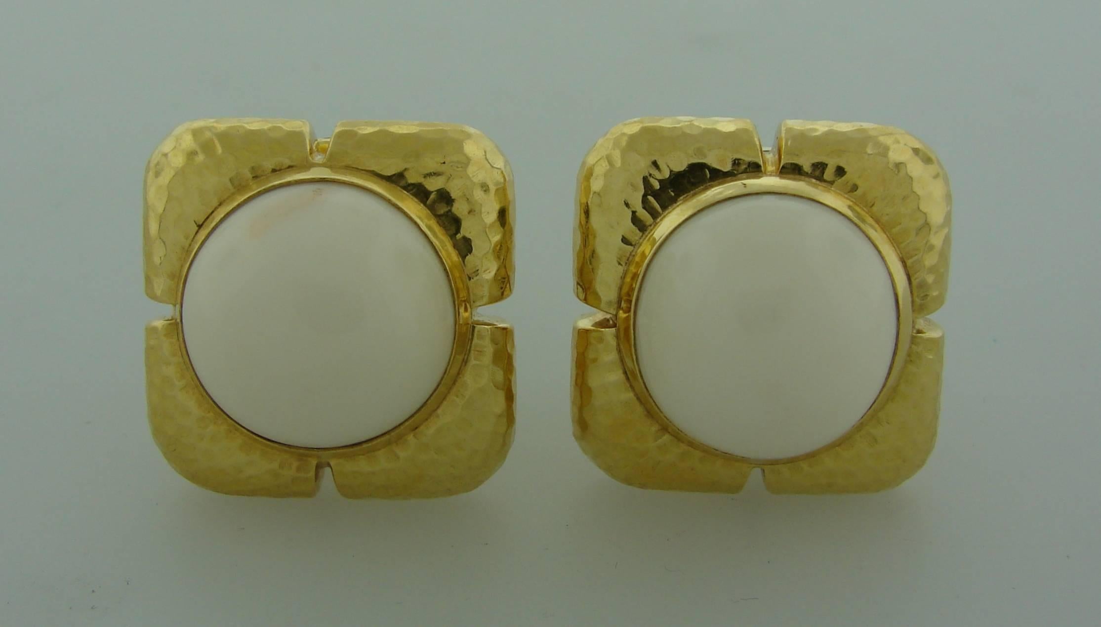 Bold yet elegant earrings created by Andrew Clunn in the 1980's. Feature round cabochon angel skin coral set in hand-hammered 18k yellow gold frame.
The earrings measure almost 1