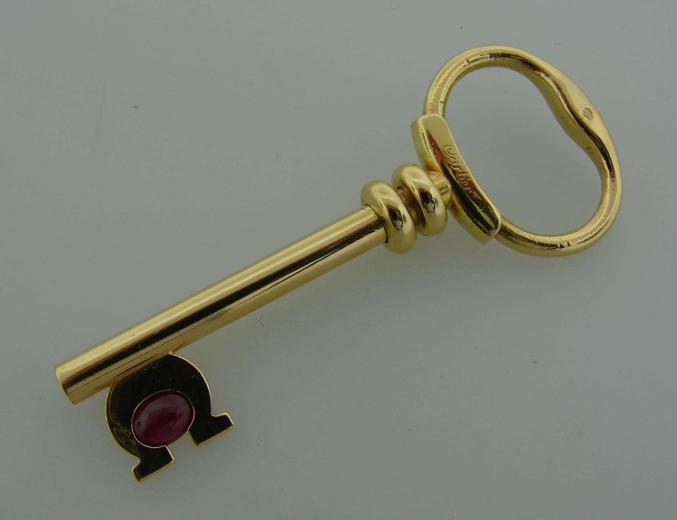 Cute and wearable key pendant created by Cartier in France in the 1970's. Made of 18k yellow gold and set with an oval cabochon ruby (5.57 x 4.37 x 2.31 mm, 0.50 carat). The pendant is 2-1/4