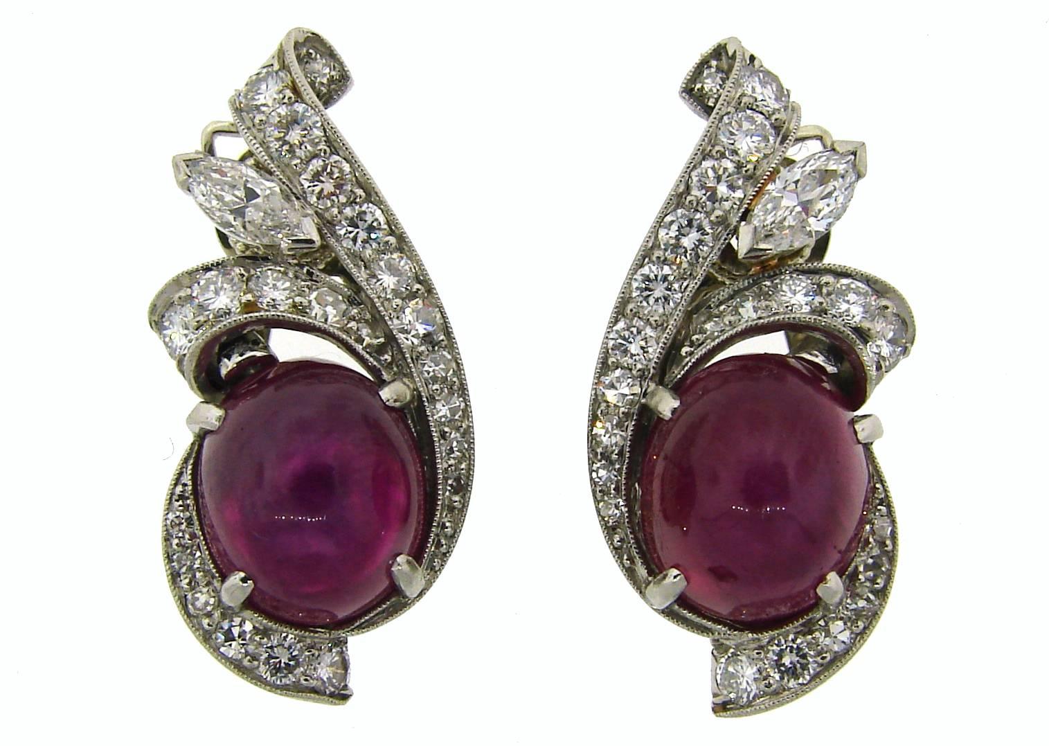 Classy and feminine Art Deco Revival earrings created in the 1960's. Feature a star ruby and diamonds set in platinum (tested). The earrings backs are made of 14k white gold (tested). The earrings are clip-on, posts can be added. 
The star rubies