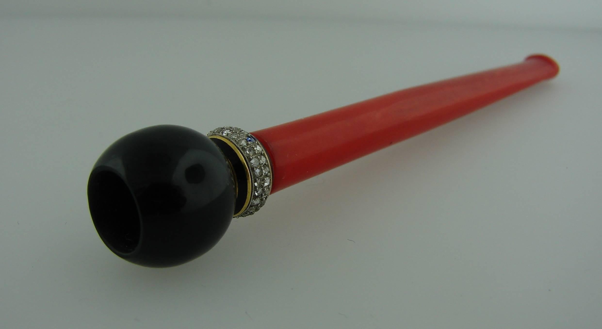 Chic cigarette holder created during Art Deco era when for the first time women were allowed smoking cigarettes in public. 
it is made of black onyx, red Bakelite, yellow gold, platinum and accented with black enamel. 
The cigarette holder is 4-1/8
