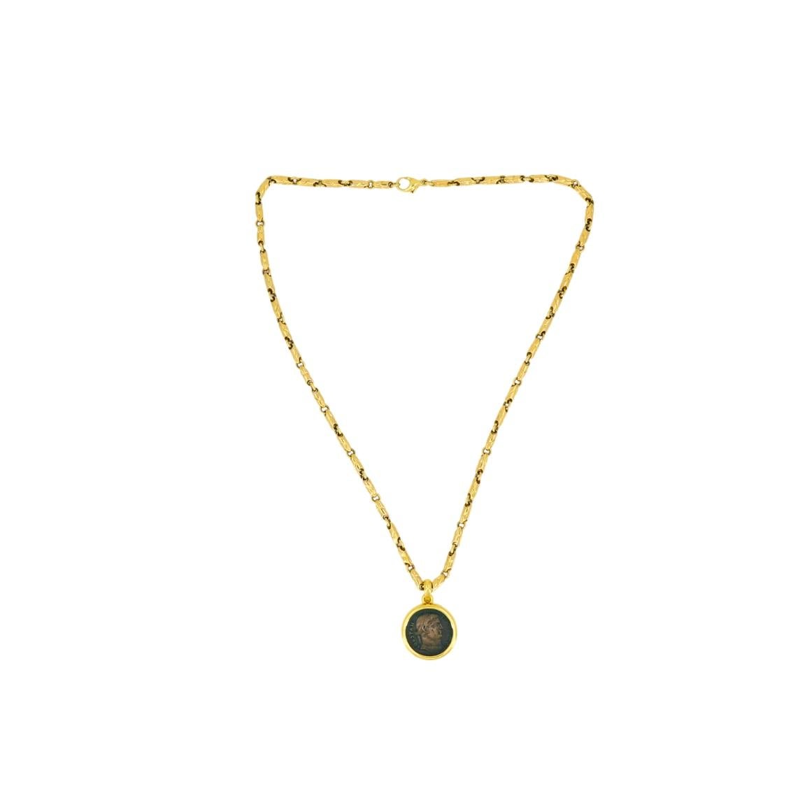 Ce collier Monet vintage de Bulgari présente une authentique pièce de monnaie romaine sertie dans un chaton lisse en or jaune 18 carats. La pièce représente l'empereur Constantin de profil, avec des inscriptions et des détails visibles. Le pendentif