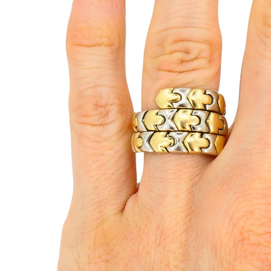 Questo anello vintage di Bulgari è realizzato in oro bicolore 18k e presenta un design avvolgente. Il cinturino è composto da maglie a forma di chevron che si alternano tra oro giallo e bianco. u2028Tre file di maglie geometriche si avvolgono in un