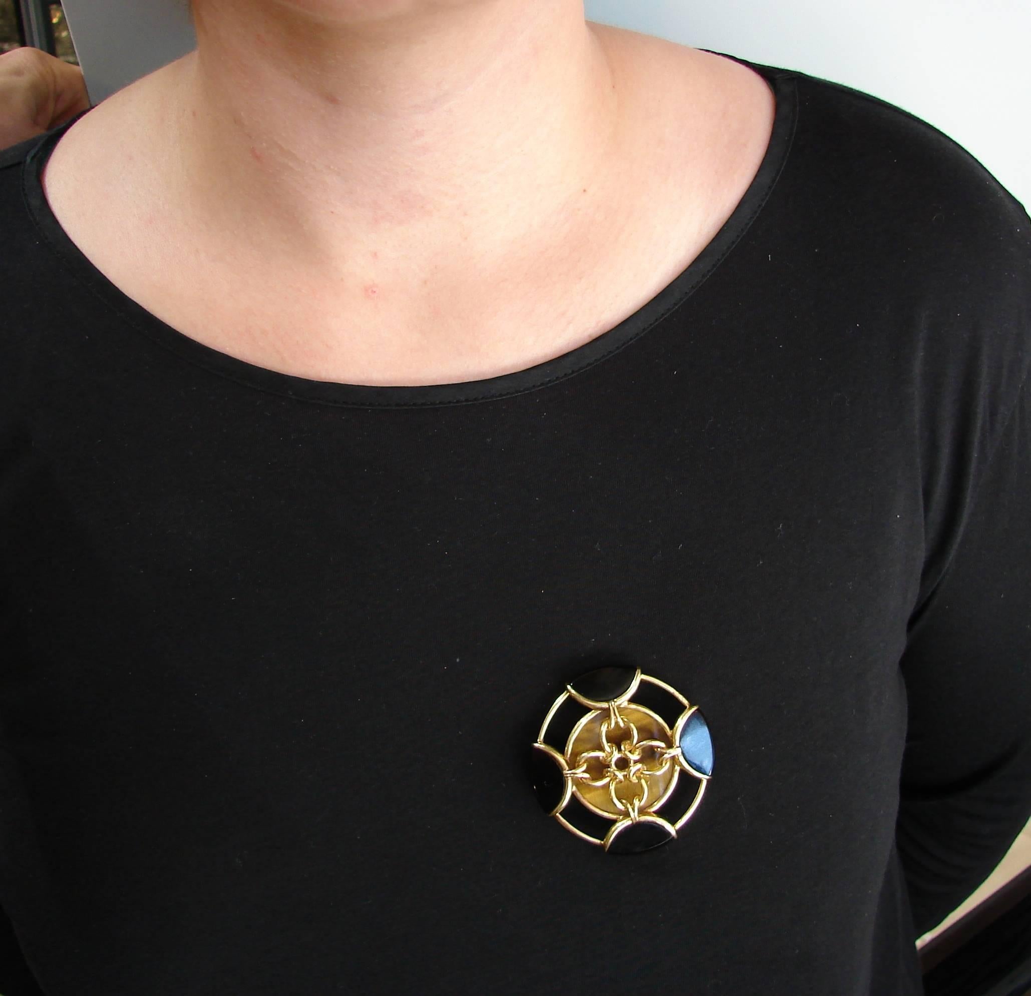 Bold and stylish pin created by Tiffany & Co. in the 1980s. Articulated and wearable, the pin is a great addition to your jewelry collection. 
It is made of 18 karat (stamped) yellow gold , tiger's eye and black onyx. 
The pin is 2 inches (5.2