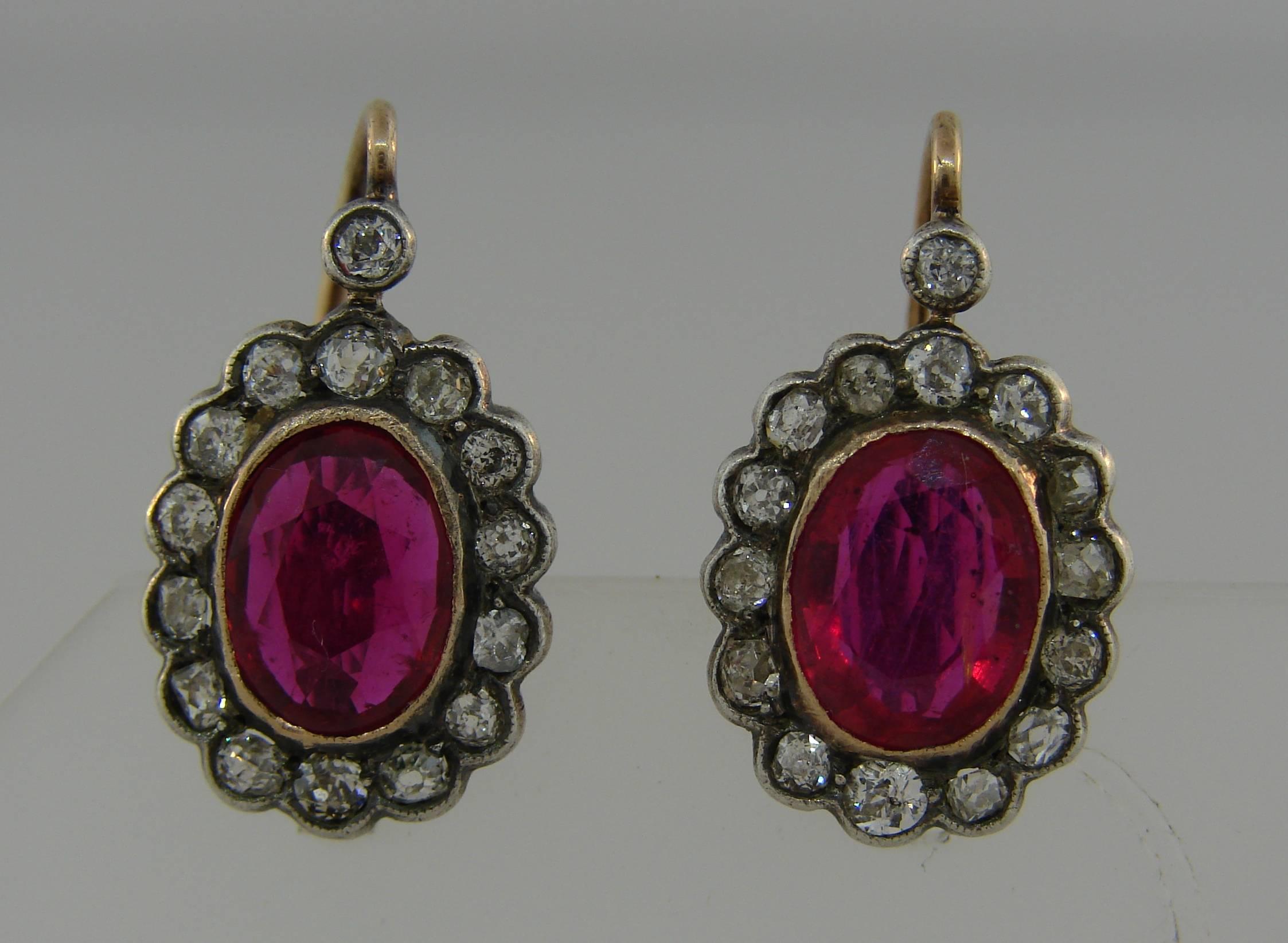 Wunderschönes Paar Cluster-Ohrringe mit Rubinen und Diamanten. Klassische und zeitlose Ohrringe, die eine großartige Ergänzung für Ihre Schmucksammlung darstellen. 

Die Rubine sind aus natürlichem Glas zusammengesetzt. Sie sind oval facettiert und