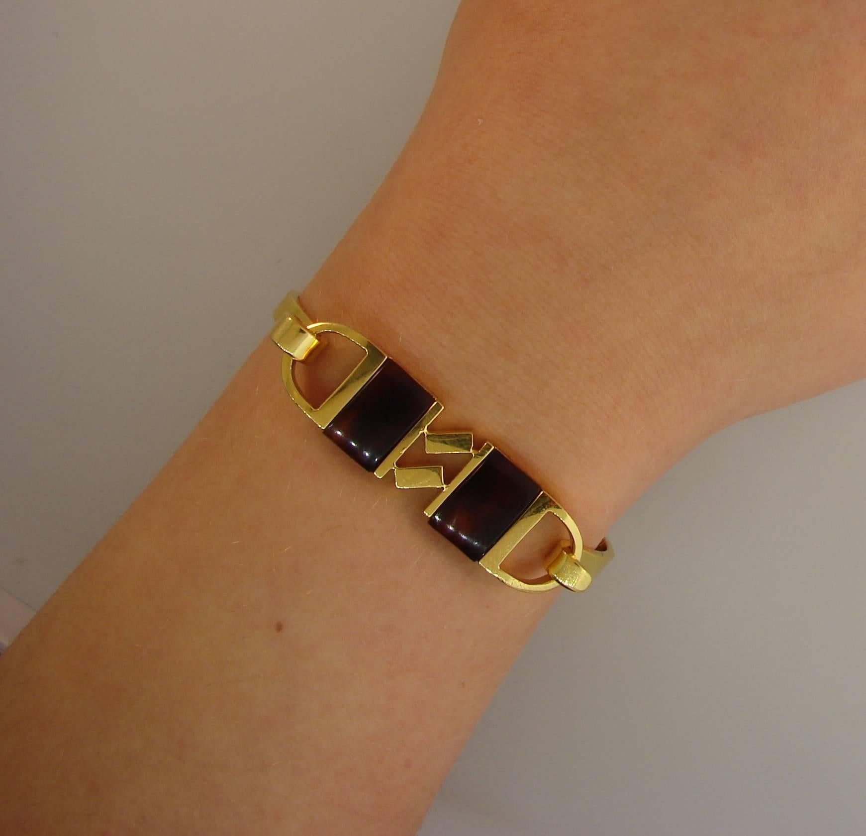 Colorful geometrical bracelet created by Cartier in 1970s. Funky and wearable, the bangle is a great addition to your jewelry collection. 
Made of 18 karat yellow gold and tortoise shell. 
Top center measures 1-3/4 x 1/2 inch (4.5 x 1.2 cm). Back is