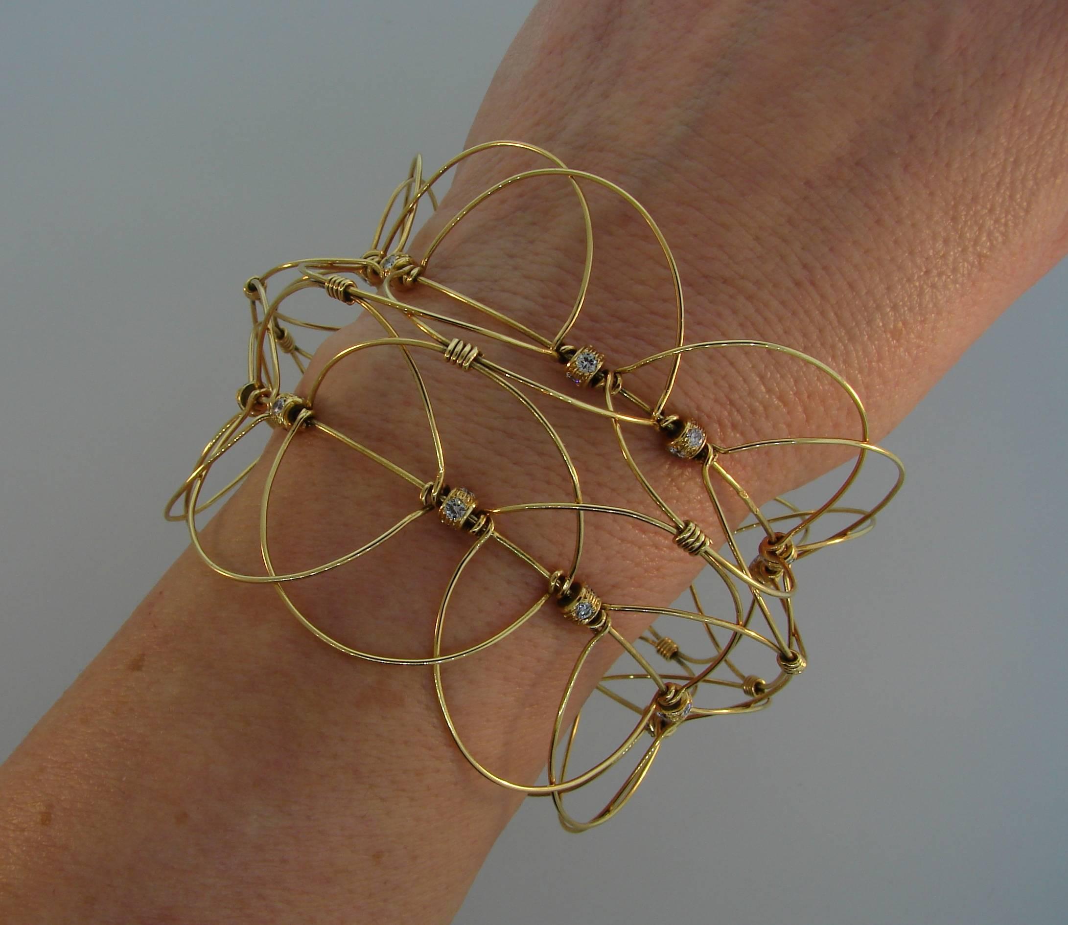 Fun and unusual openwork bracelet that can be worn in many different ways.Versatile and wearable, the bangle is a great addition to your jewelry collection. 
Made of 14 karat (tested) yellow gold and set with approximately 3.20 carats of round