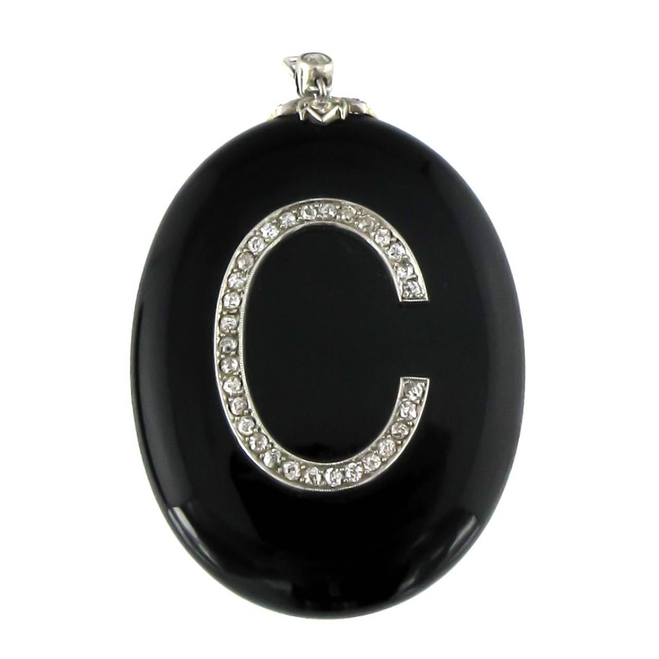 A jewelled mourning locket with oval black onyx and diamond 