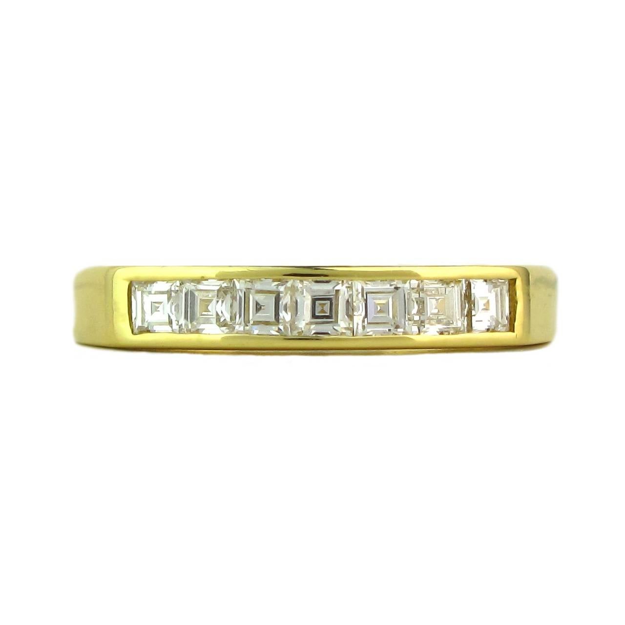 An 18ct yellow gold half channel eternity ring, comprising seven square step cut diamonds, estimated to weigh 0.44cts in total, G/H colour (near colourless), VS clarity (very slightly included - not visible to the naked eye). 

Designed by luxury