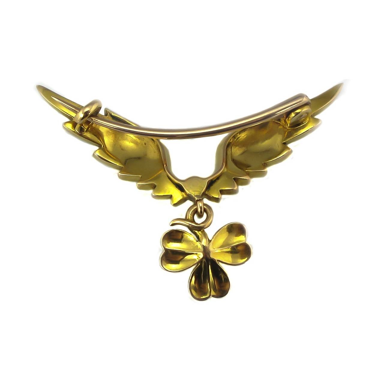 A beautiful 15ct gold brooch, circa 1910 - 1920s. Designed as green and white enamel angel wings with a green three leaf clover/shamrock enamelled droplet with pearl accents. Tests as 15ct gold.

Measurements: 4cm x 2cm.

The shamrock has been