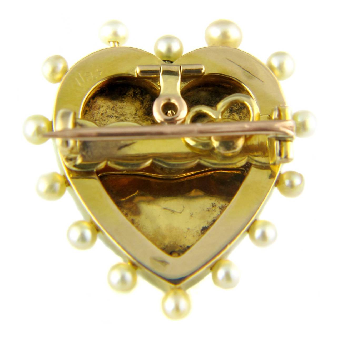 A Victorian heart pendant/brooch, comprising a central rose cut diamond and natural pearl double heart centre, mounted on a white and red guilloche enamel heart with pearl edging, mounted in 15ct gold and silver.

This piece has been fitted with a