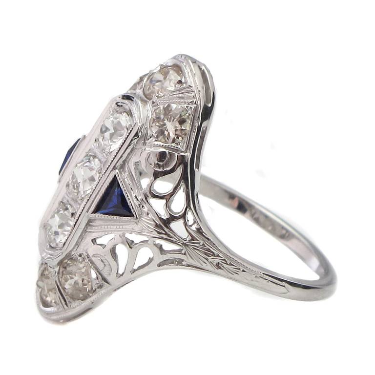 An Art Deco sapphire and diamond ring. Beautifully crafted in 18ct white gold, this beautiful navette-shaped ring comprises nine old European-cut diamonds, weighing approximately 1.25 carats in total, accented by a pair of trilliant-cut