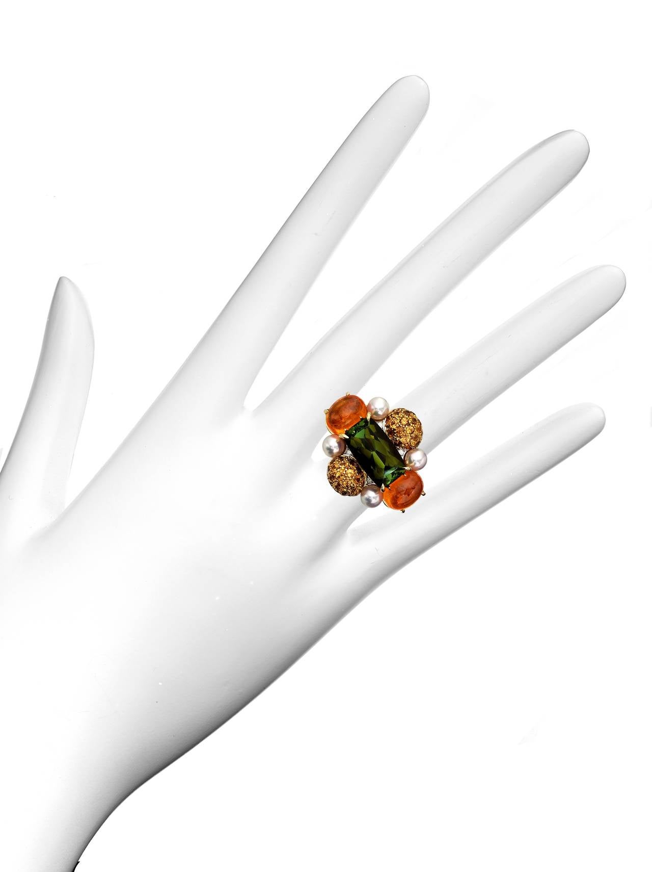 Fire Flower
One-of-a-kind, ring by Abellán New York

One-of-a-kind Mandarin Garnet Diamond Gorgeous Ring. A ring with royal vibes, featuring a gorgeous, a rectangular green Tourmaline center stone surrounded by vivid bead set Mandarin Garnets,