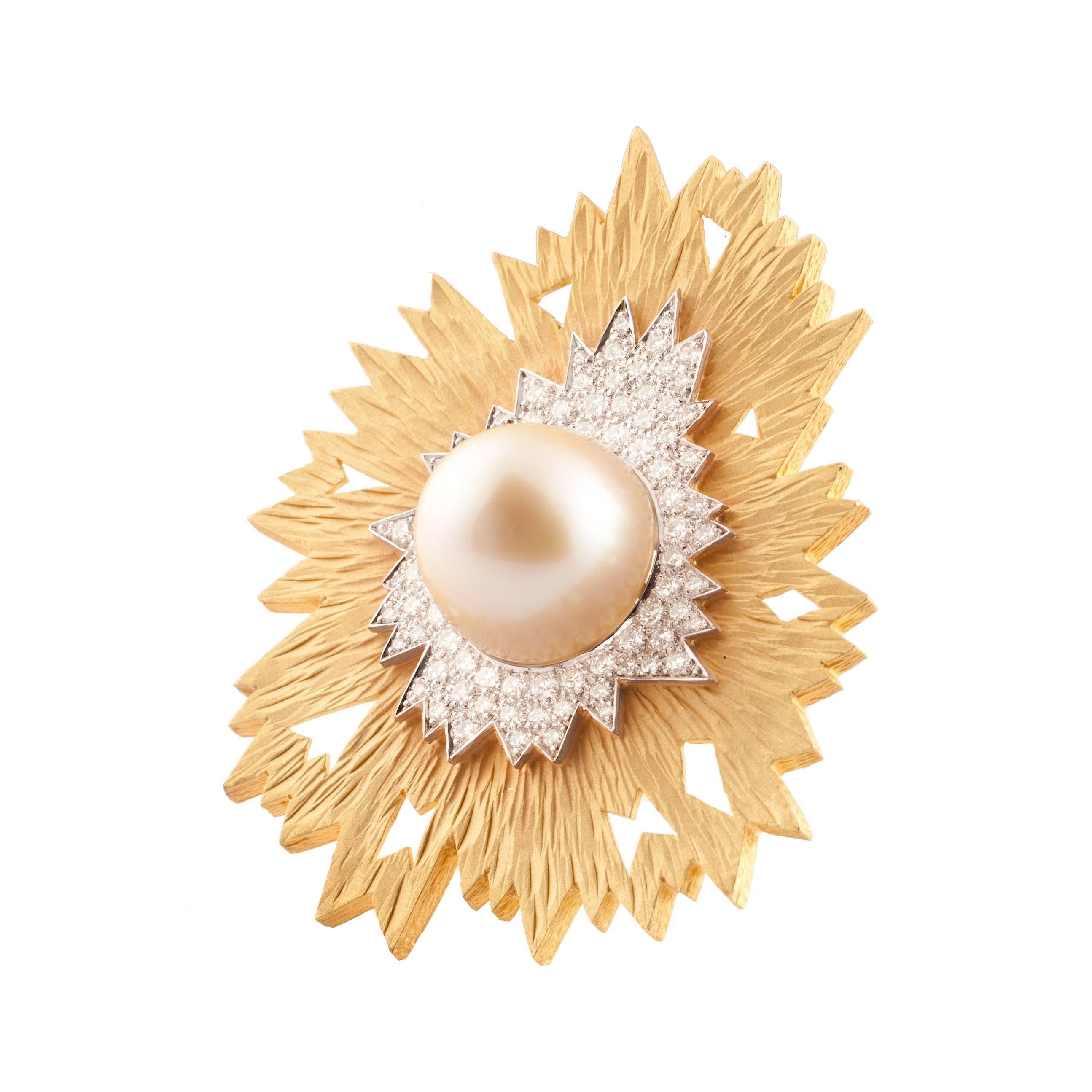 Designed by Andrew Grima in 2002
Brooch/pendant featuring sandblasted yellow gold, mimicking the appearance of wood.  The centre is pavé-set with brilliant cut diamonds (2.7cts) surrounding a large golden South Sea pearl (43cts).  Signed GRIMA, 750