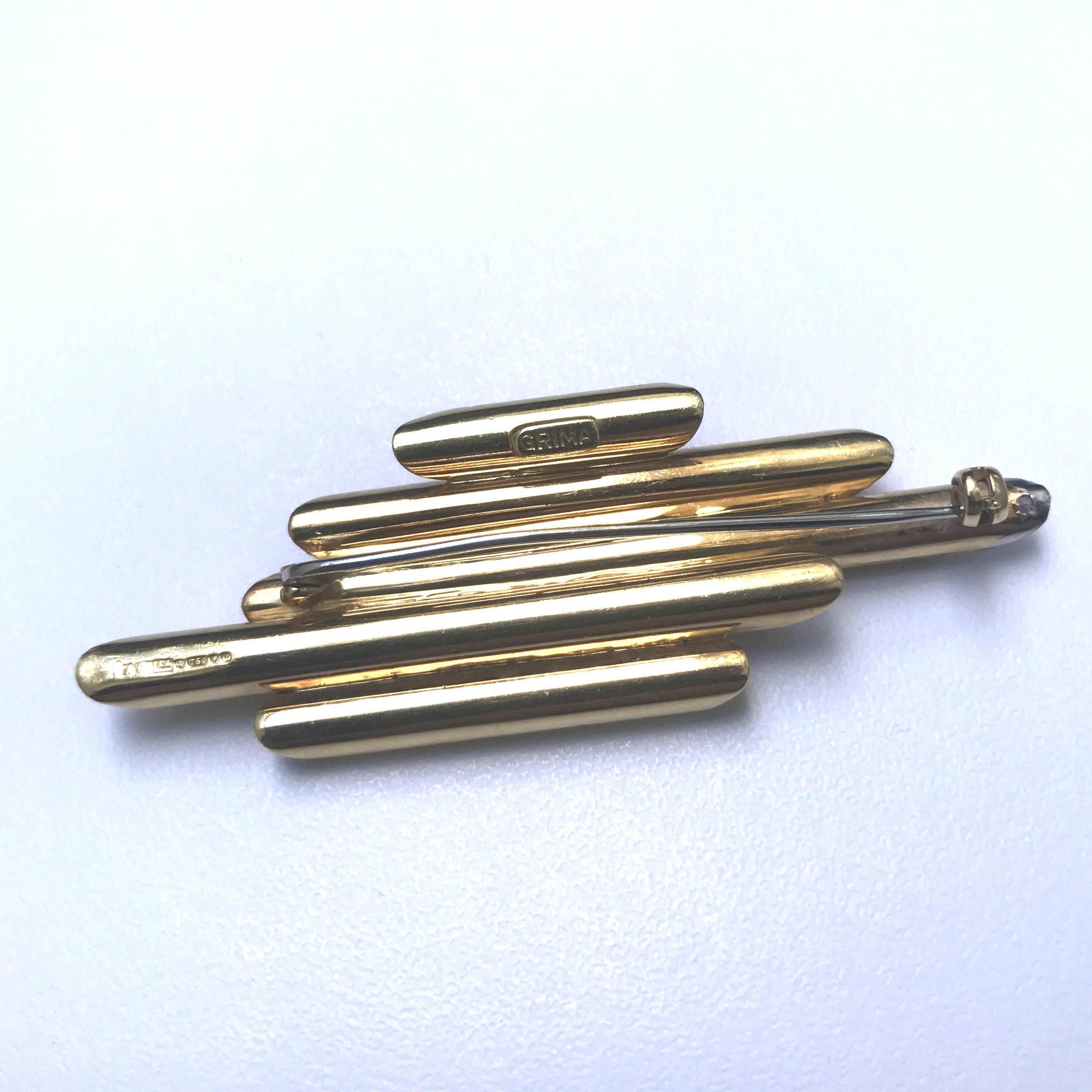 Designed by Andrew Grima in 1977
This brooch features textured gold tubes of varying lengths, one set with brilliant cut diamonds. Signed GRIMA, London hallmarks for 1977

About Grima
Andrew Grima was one of a handful of British designers who