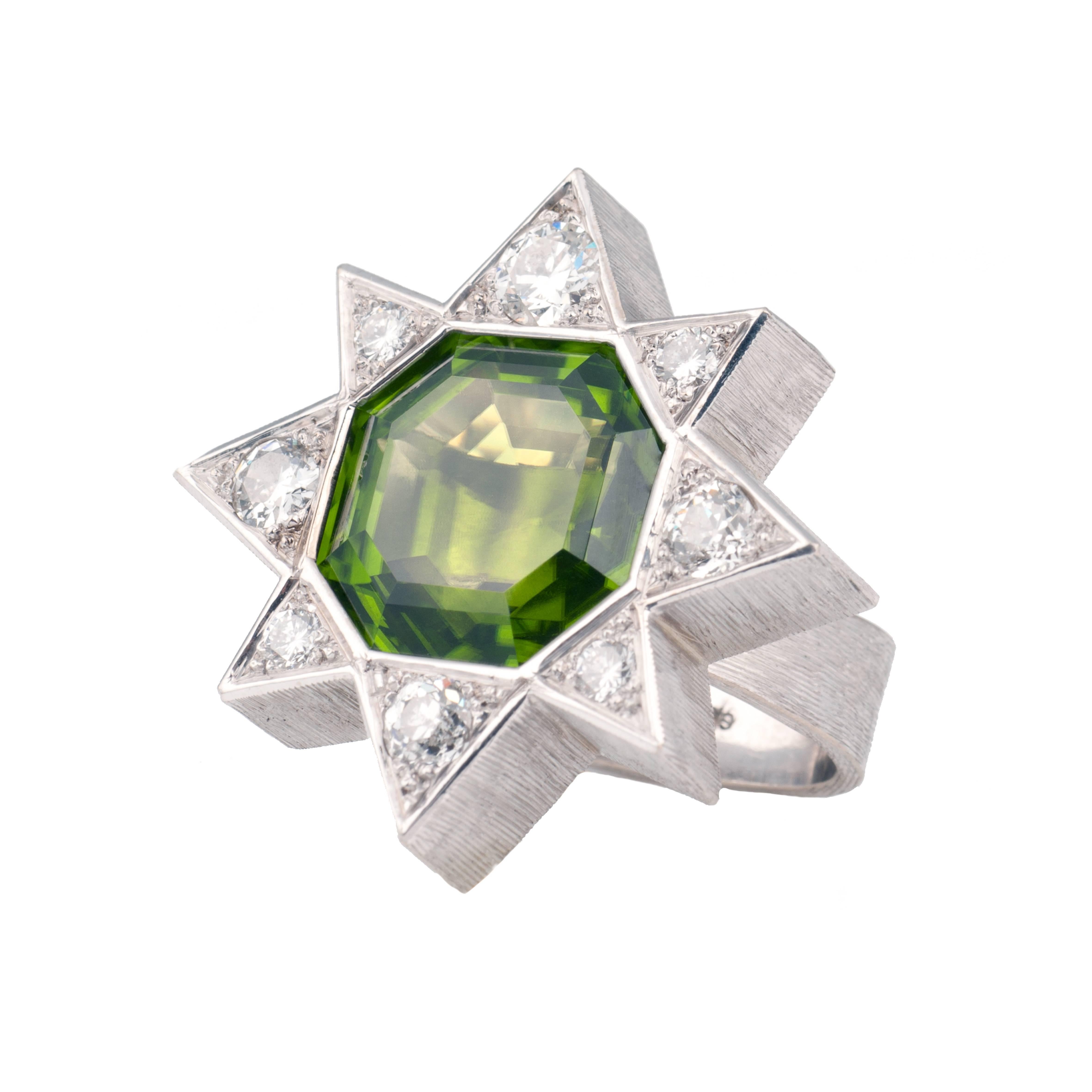 Designed by Andrew Grima in 2000
This cocktail ring features a large octagonal-cut peridot (23.15cts) set in white gold surrounded by eight brilliant-cut diamonds (1.9cts).  
Stirrup-shaped shank. Signed GRIMA, London hallmark for 2000. 

UK Size: M