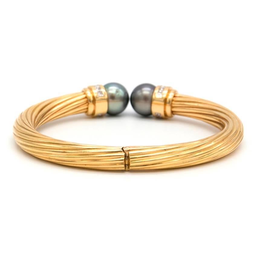 Luisa G Brito gold bracelet with clasping closure, ribbed detailing along the gold and small diamonds encrusting two grey pearls. 

Approx Measurements: Diameter:7cm
Fabric: Gold
Size: One Size
Label Details: One Size
Colour: Gold

Conditions