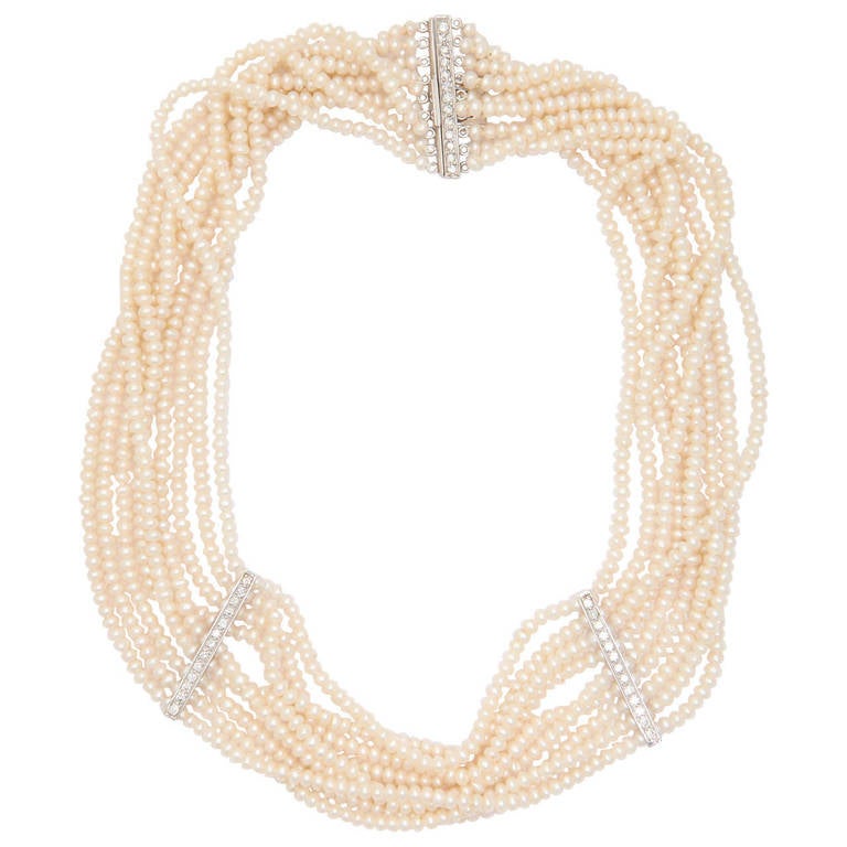 There are 9 rows of 3 mm. fresh water pearls divided by 18 kt white gold and diamond bars and clasp. This choker stands up against your neck like the chokers in Edwardian and Victorian times. The height of the choker is 1 1/8 in. high. The bottom is