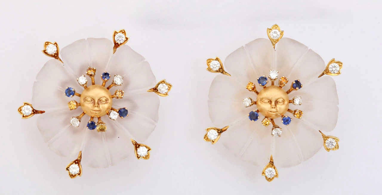 Charming and unusual  finely carved frosted crystal earrings surrounded by diamond leaves. The surprise center is a tiny fairy face in the center of a sapphire, white diamond and yellow diamond spray.

Securing the earring is an oversize clip that