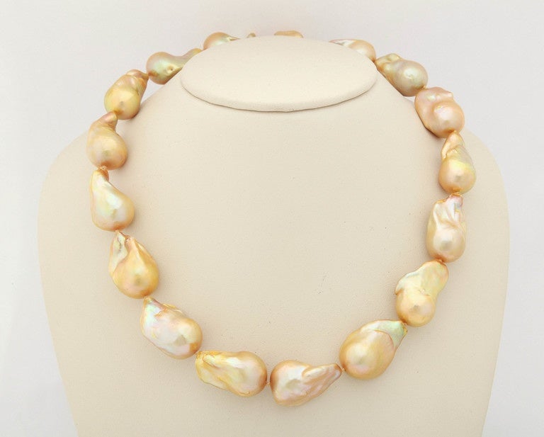 Large 16 x 20 mm golden baroque pearls are finished with an 18 kt clasp. The total length of the necklace is approximately 17 in. and consists of 16 large pearls. The luster is superb on these pearls and will be an special strand added to your