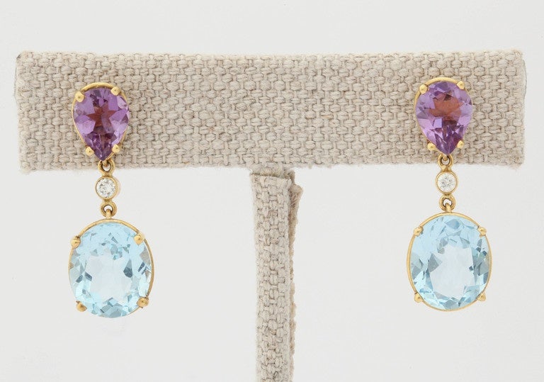 What a delightful color combination, light purple and aqua blue. The top pear shaped stones are a light amethyst, 9 x 11 mm and  the bottom stones are an aqua-color blue topaz oval measuring 10 x 14 mm. The stones are connected with 5 point round