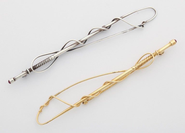 Elegant and hand made driving whips in sterling and 18 kt gold. Into the handle,at the end of each whip is a cab ruby. Stunning to wear as a set on a lapel or individually as a stock pin. Can be sold individually.