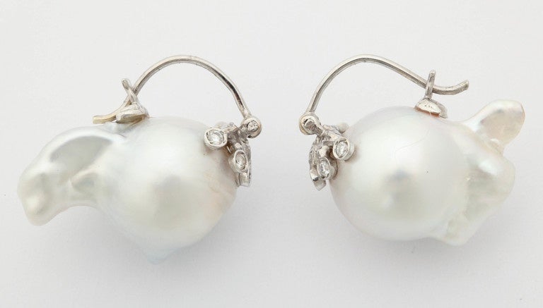 Beautiful baroque South Sea pearls are mounted in a creative and unconventional way. The front part of the earring sports little tentacles with bezel set white diamonds. Total weight of diamonds is .12ct. This earrings are for someone who likes