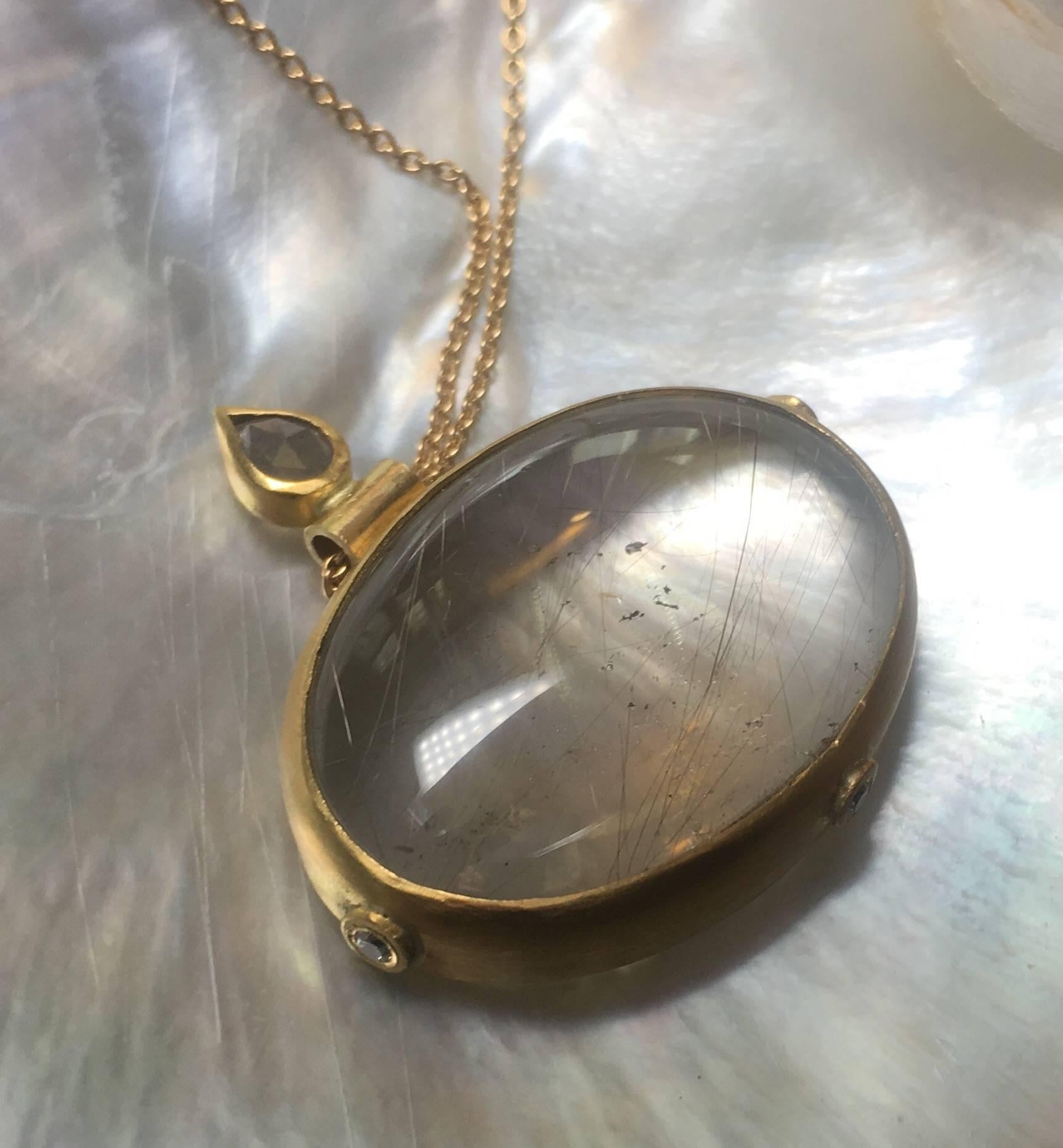 Bonoculo necklace. The loupe of jeweler Josephine Bergsoe, old-fashioned, as a gorveness would wear it, but the lens is made from a rutile quartz in a 22 karat yellow gold bezel adorned with three 0.04 ct. tw vs brilliant cut diamonds. 
On top of