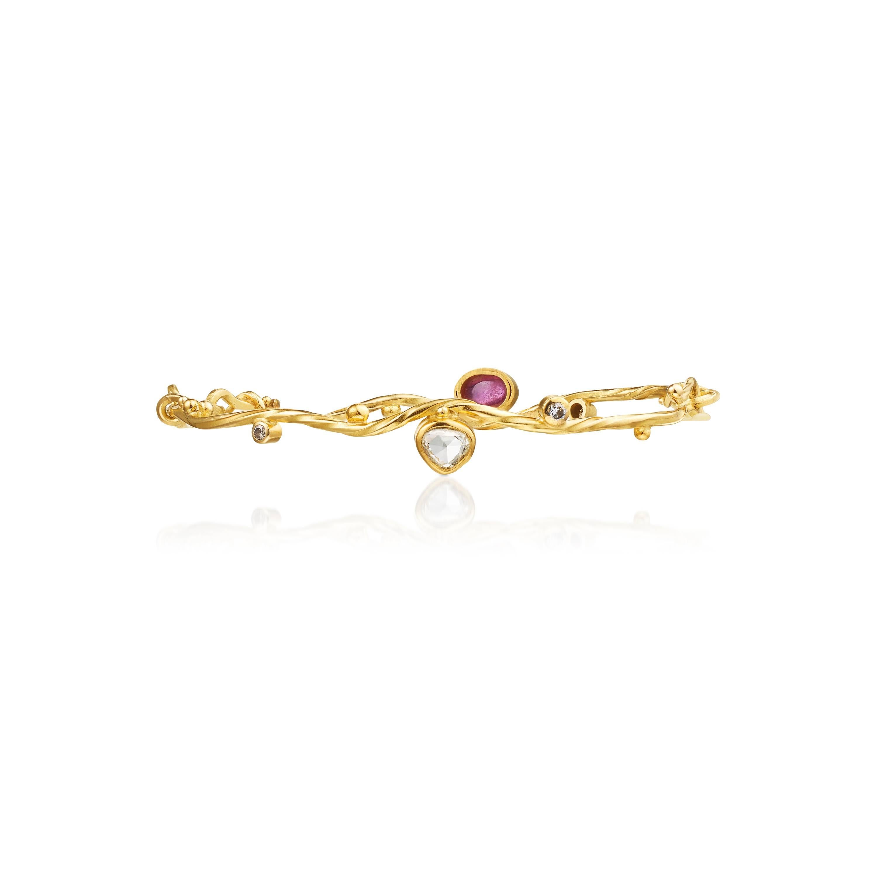 This beautiful seafire bracelet brings memory of the flourishing phlankton in the Oceans. Brought to life by movements in the surface.  
It is made in 18 and 22 karat yellow gold with a pink sapphire, 0.43 ct. antique cut diamond, 0.04 ct. and 0.06