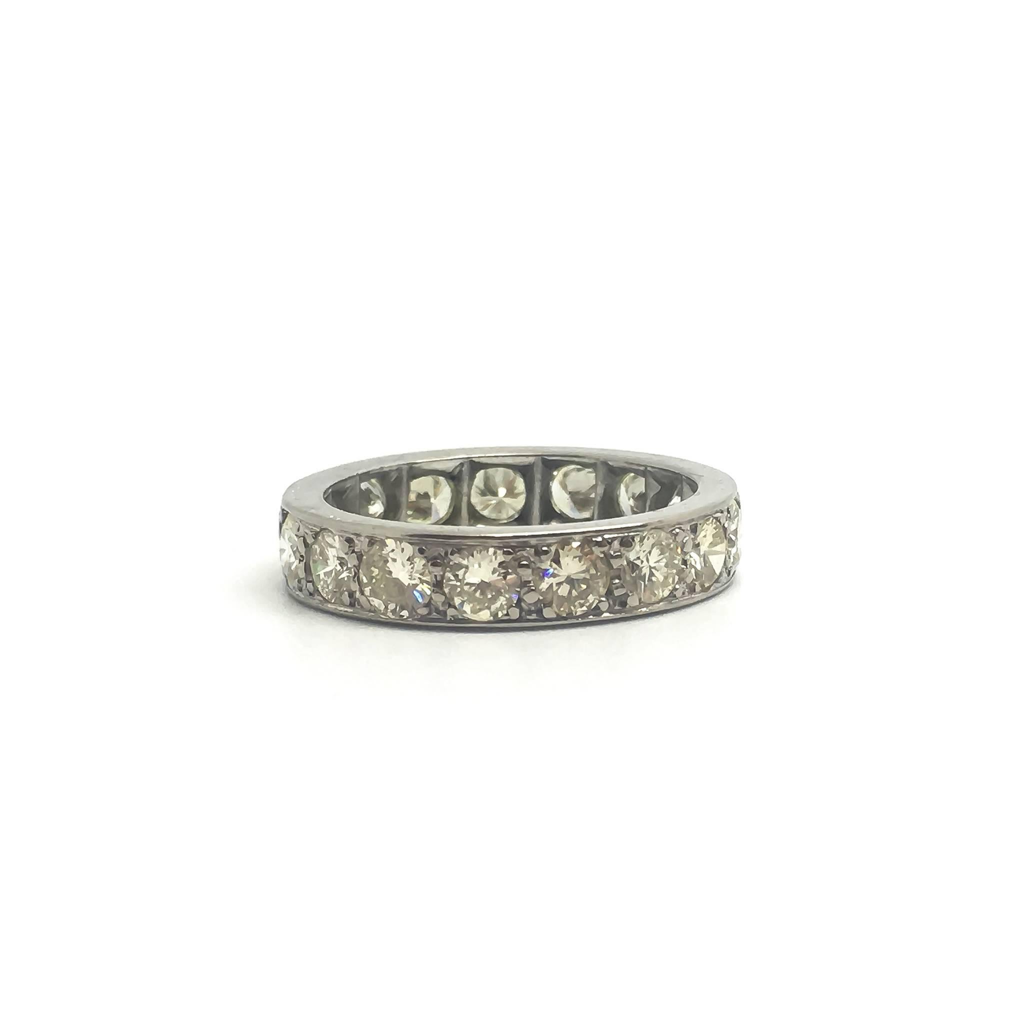 A diamond set palladium eternity ring circa 1950.

The brilliant round cut diamonds are approximately 0.17ct each giving a total estimated weight of 3 carats.

UK size P 1/2
US size 7 3/4

Diamonds are estimated VS2/SI clarity and J/K colour. 
