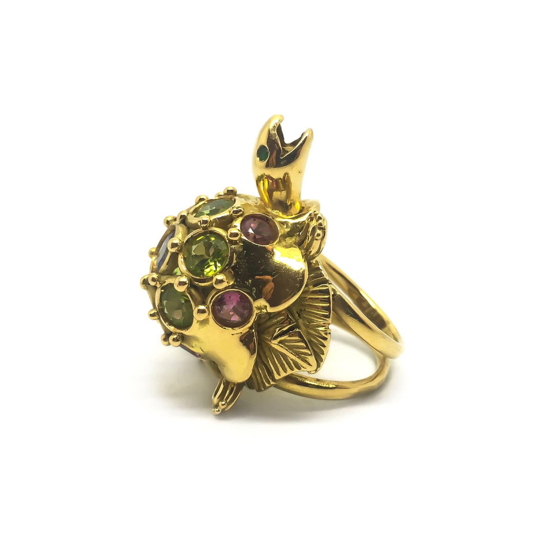 A quirky large gold tortoise/turtle ring.

Weighing 28.5g this is an eye-catching piece of jewellery! 

The ring is set with green peridot, pink tourmaline and purple iolite.

The turtle spans approximately 3cm x 4cm.

UK size N
US size 6 1/2