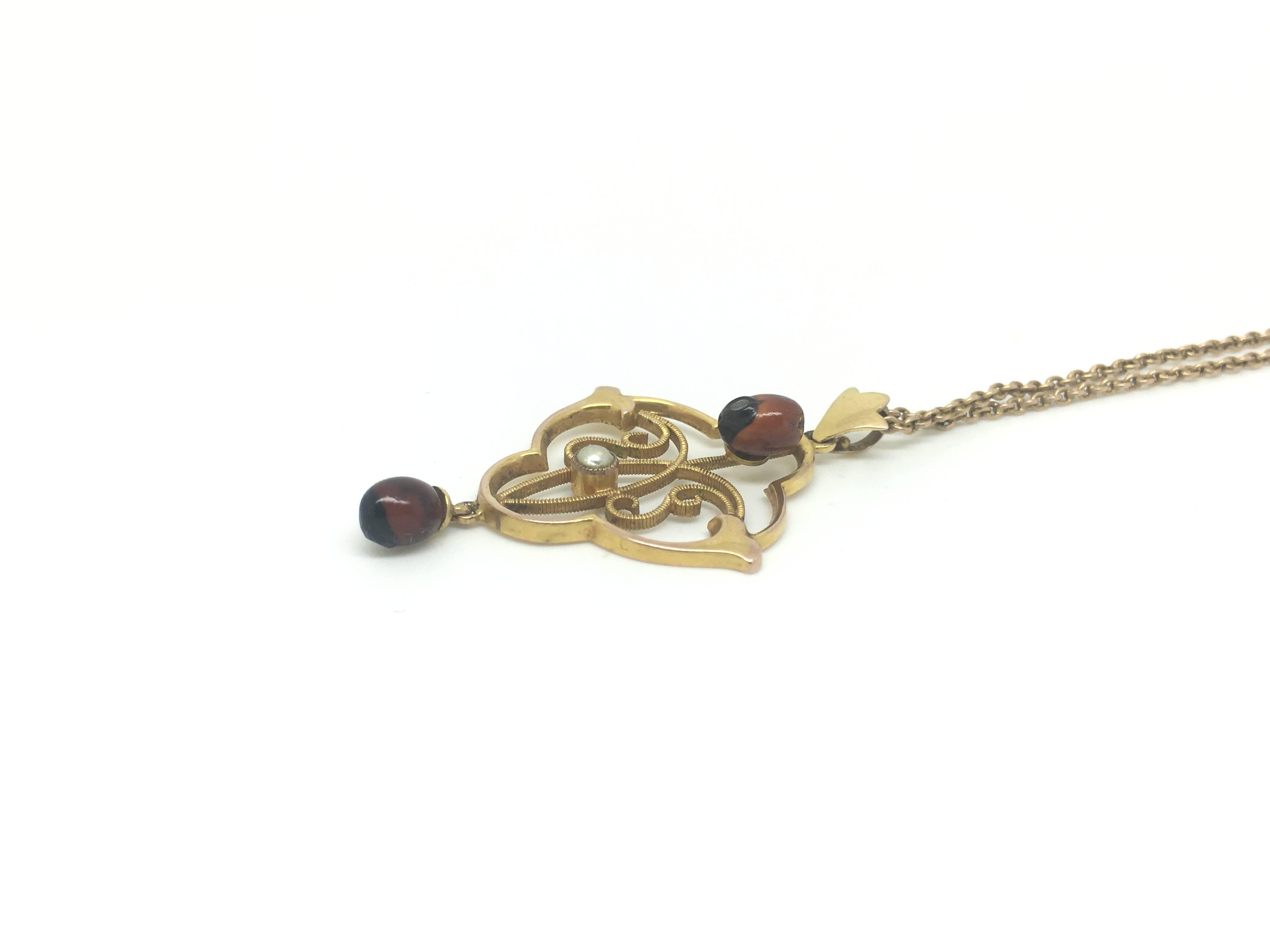 This highly unusual necklace features a pendant set with two Jequirity beans and a small pearl to the center.

The red and black beans look like small ladybirds.

NB makers mark. 9ct gold and date mark for 1910.

9ct gold and date mark for