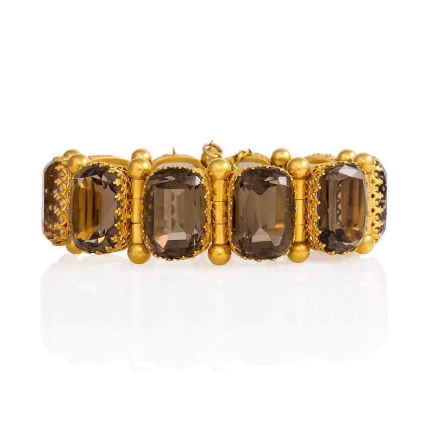 An antique gold bracelet comprised of cushion-cut smoky topaz in filigree basket settings, in 15k. Dated February 25, 1875.