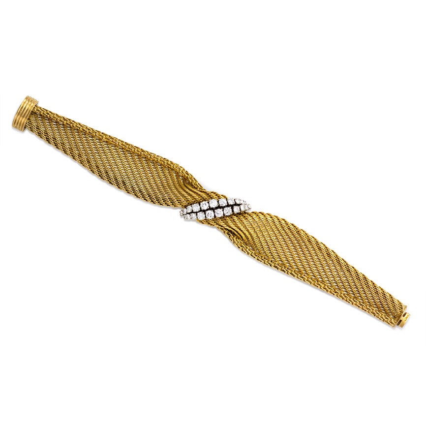 A woven gold bracelet of draped and twisted design with a double row of tapering diamonds, in 18k and platinum. France